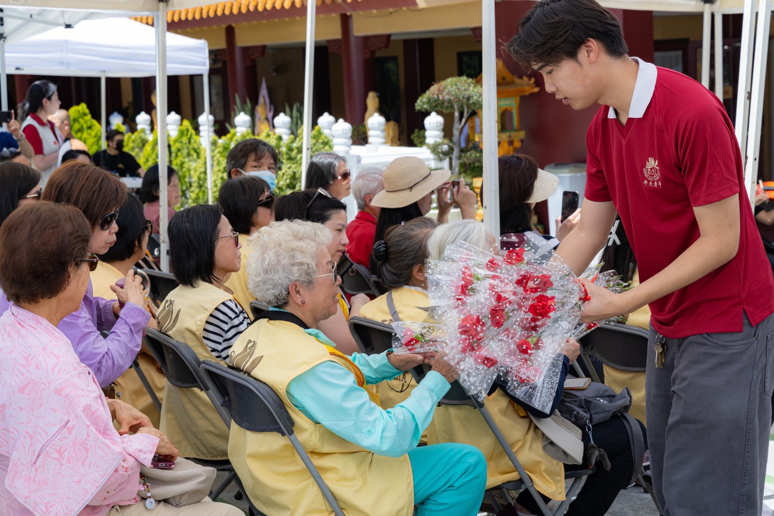 青年團員為現場每位女性貴賓獻花，祝福媽咪們母親節快樂！